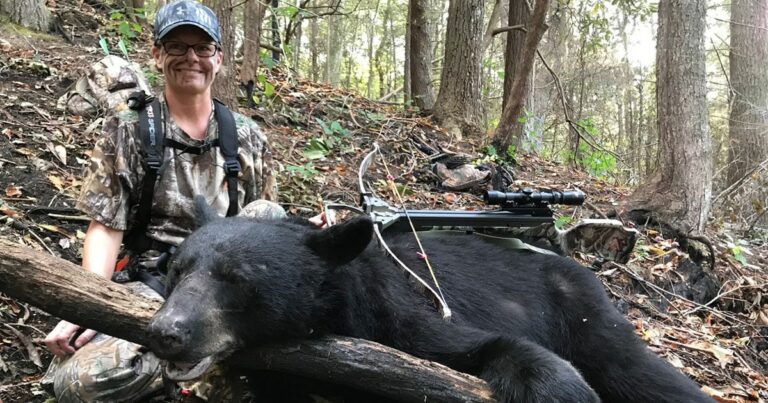 A lady with a bear she harvested with a crossbow.