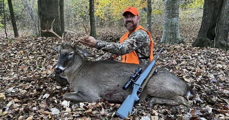 The author with a buck in the woods.