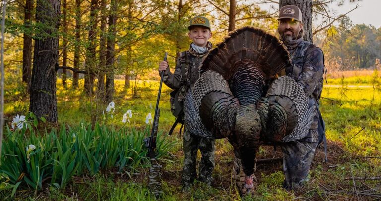 A father and son with a big Georgia turkey.