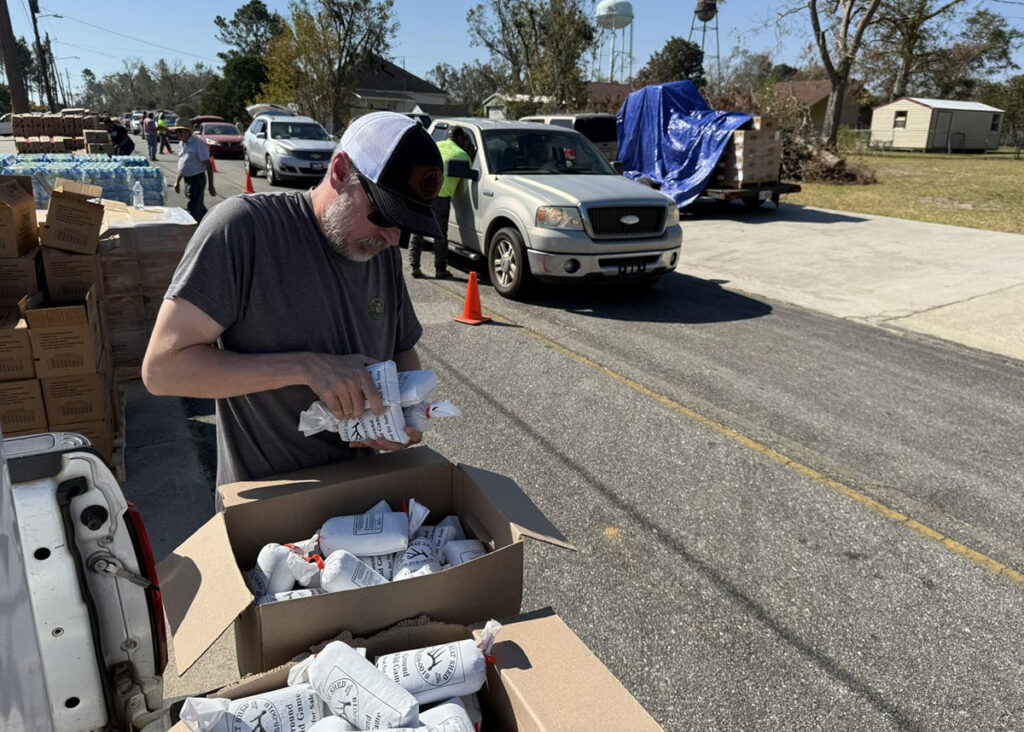 Volunteers pass out venison to hurricane victims.