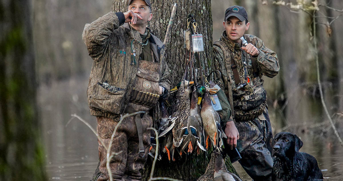 Two duck hunters in flooded timber.